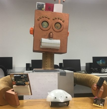 A Robot holding a Micro:Bit, an Arduino, and a Raspberry Pi