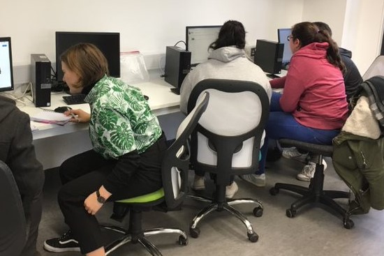Female CS students working at a laptop
